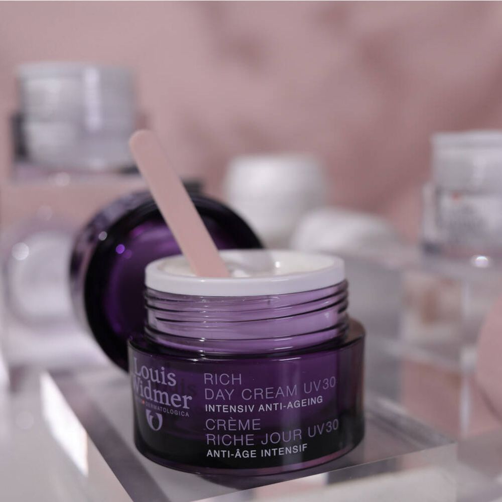 Pot violet ouvert avec spatule. Inscription: Louis Widmer, Rich Day Cream UV30, Anti-Âge.