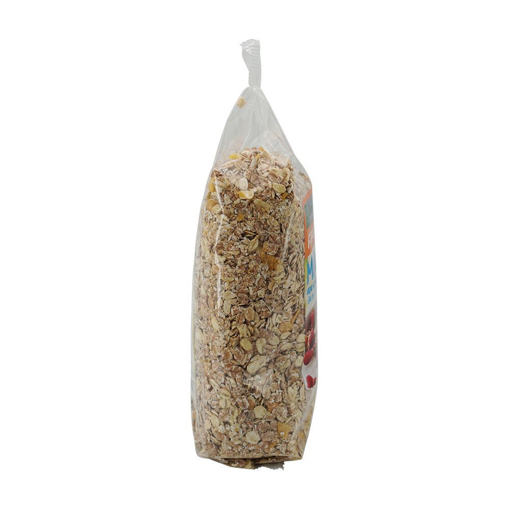 Zijaanzicht van de muesliverpakking. Transparante folie, gevuld met muesli. Bovenkant gesloten.