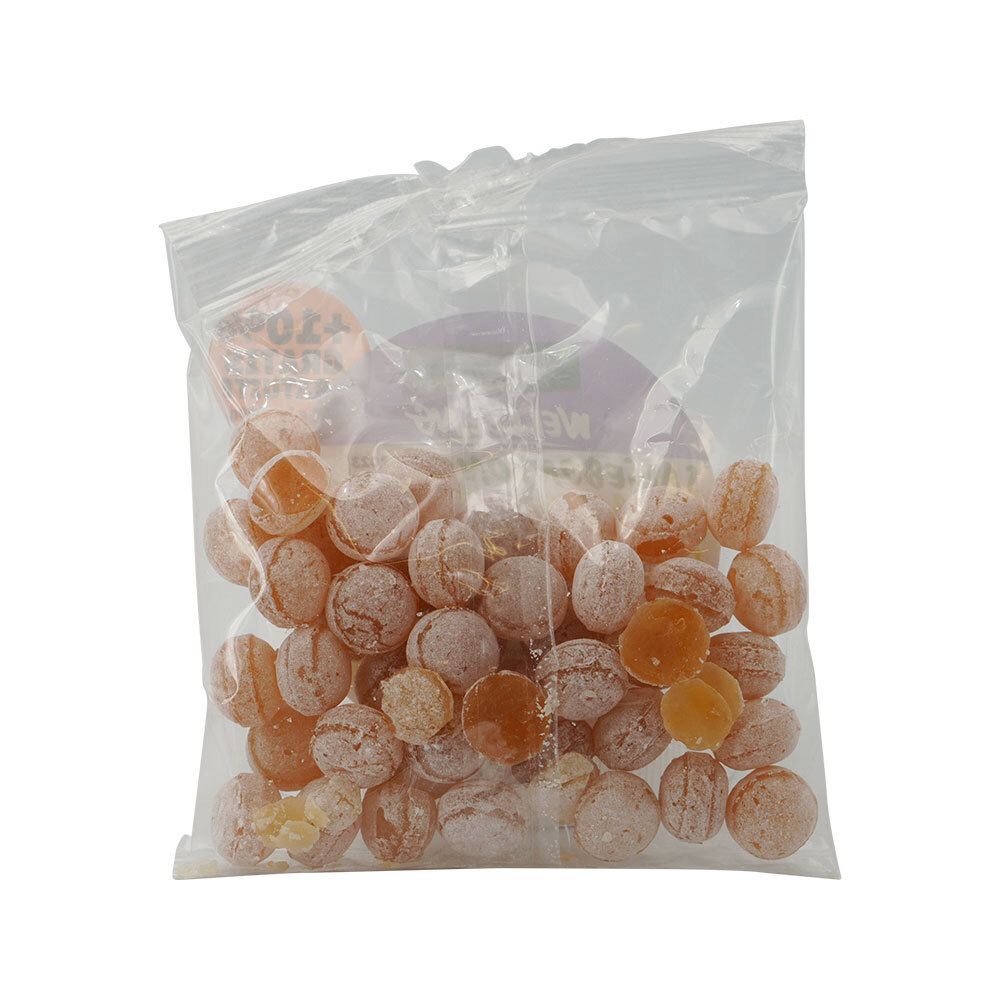 Zakje met snoepjes. Ronde, amberkleurige snoepjes in transparante verpakking.