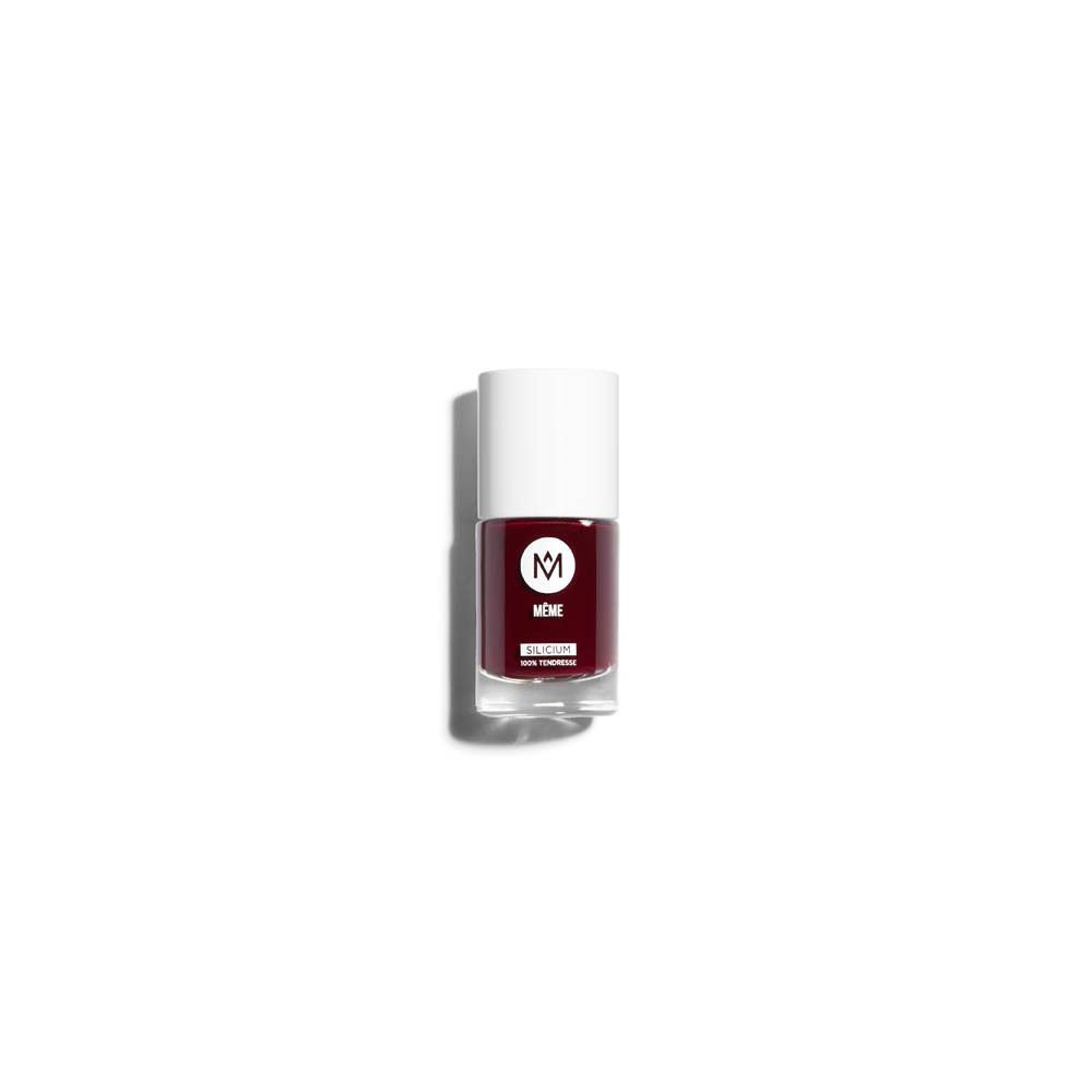 Donkerrode nagellakfles. Witte dop, transparante glazen fles. Opschrift: MÊME.