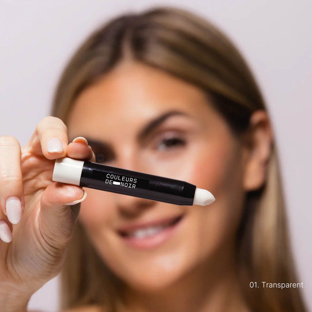 Personne tenant Chubby LipBalm 01 Pearl. Bâton noir à embout blanc, gros plan.