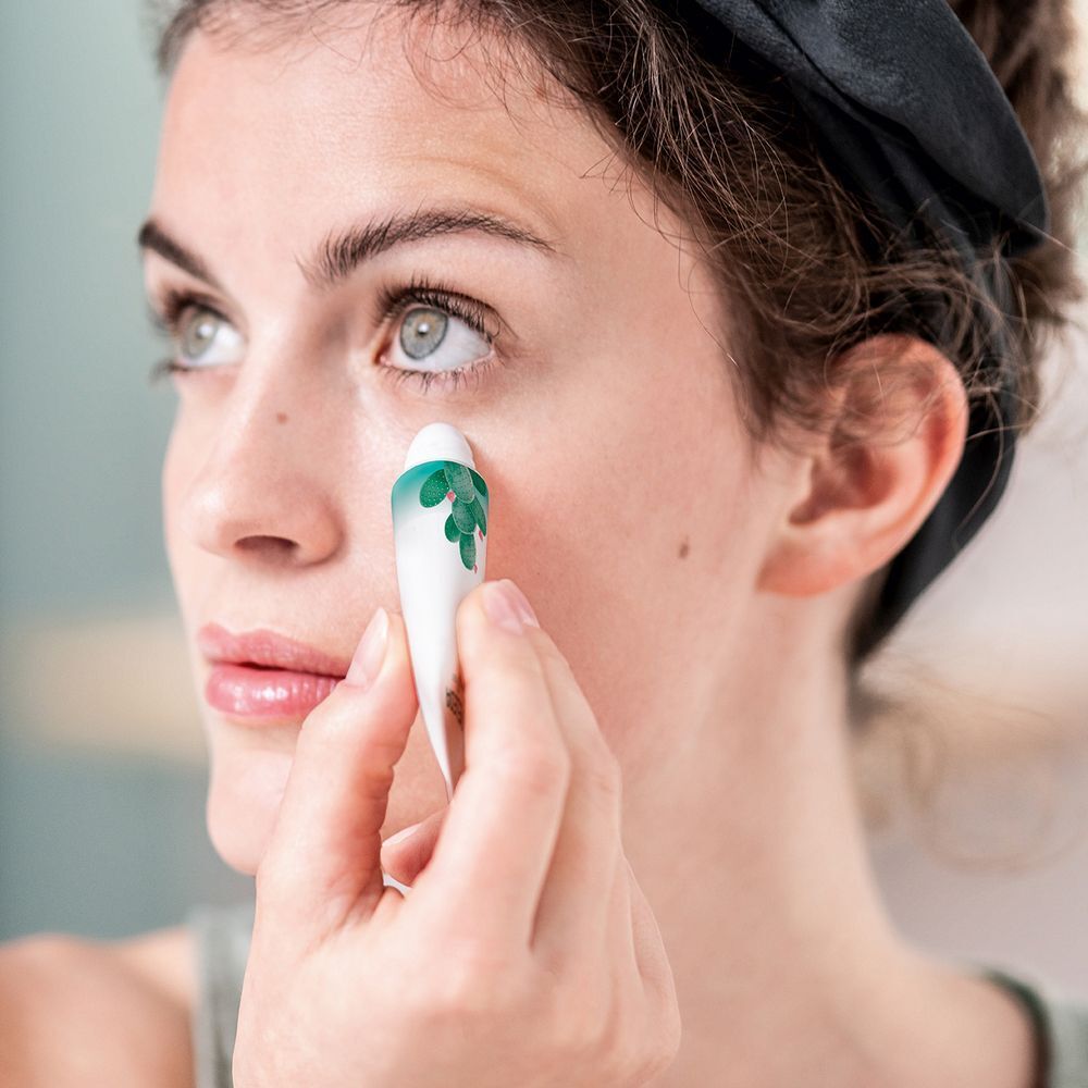 Vrouw brengt ooggel aan met roll-on applicator. Product wordt onder het oog aangebracht.