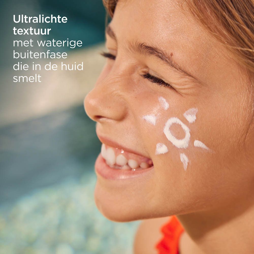 Ein Kind mit Sonnencreme in Form einer Sonne auf der Wange. Ultraleichte, wässrige Textur.