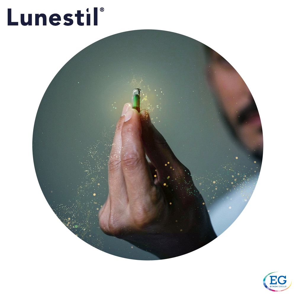 Main tenant une gélule verte. Effets de lumière en arrière-plan.