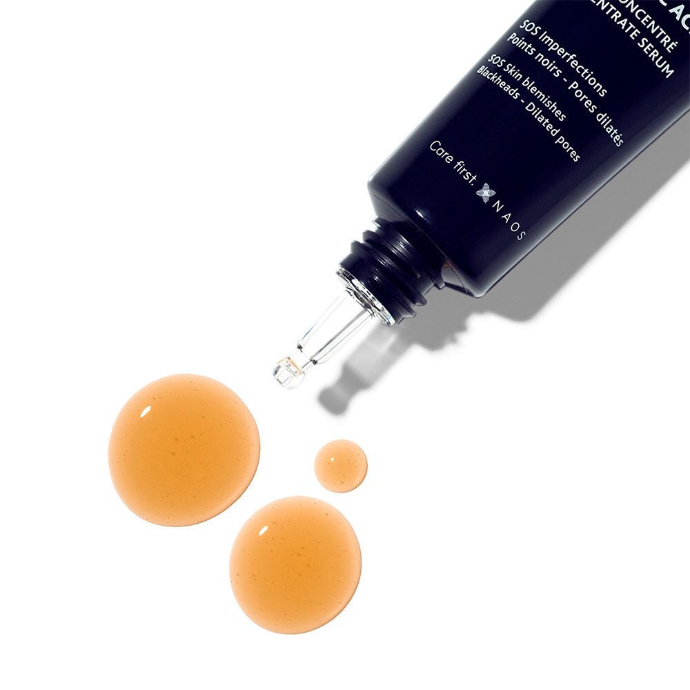 Drie oranje serumdruppels. Druppelaar van een serumtube. Op witte achtergrond.