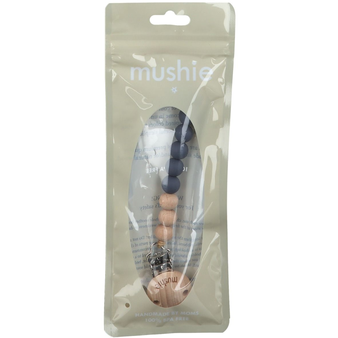 Schnullerkette in transparenter Verpackung. Enthält Holz- und blaue Silikonperlen. Marke: mushie.