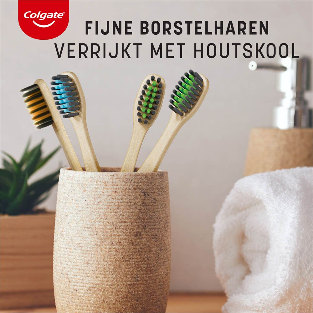 Meerdere Colgate bamboe tandenborstels. Groene, blauwe en oranje borstelharen, bamboe handvat. Tekst: Holzskool.