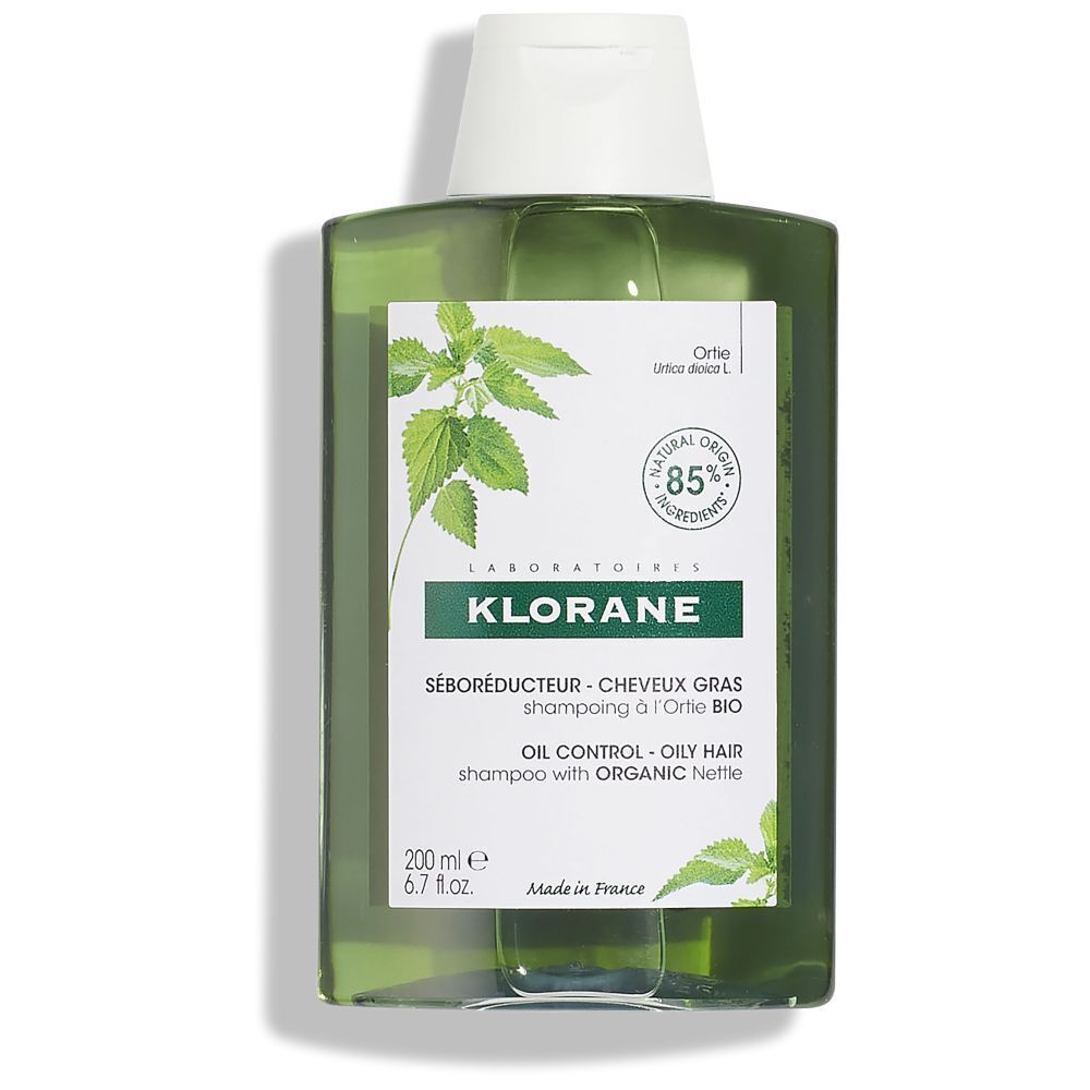 Klorane shampoo fles. Tekst: 85% natuurlijke ingrediënten. Vermindert talg. Kleine lettertjes.