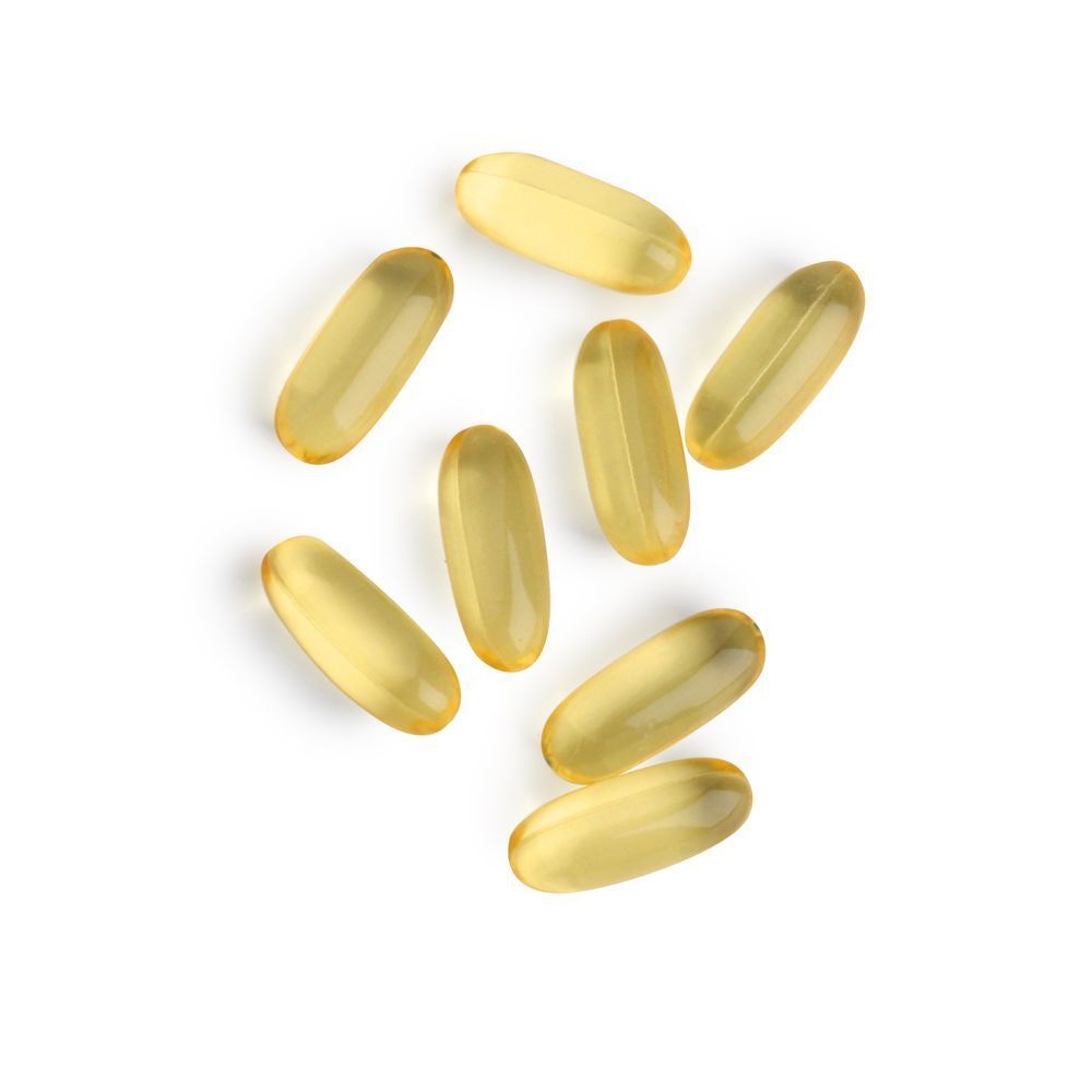 Zeven gele, ovale capsules op witte achtergrond. Geen opschrift.