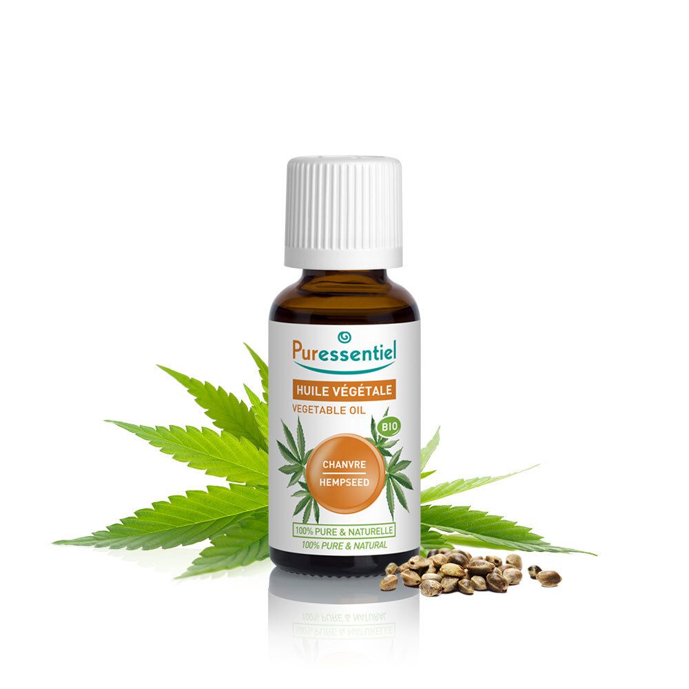 Bruine glazen fles met witte dop, omringd door hennepbladeren en zaden. Opschrift: Huile Végétale, Chanvre Hempseed.