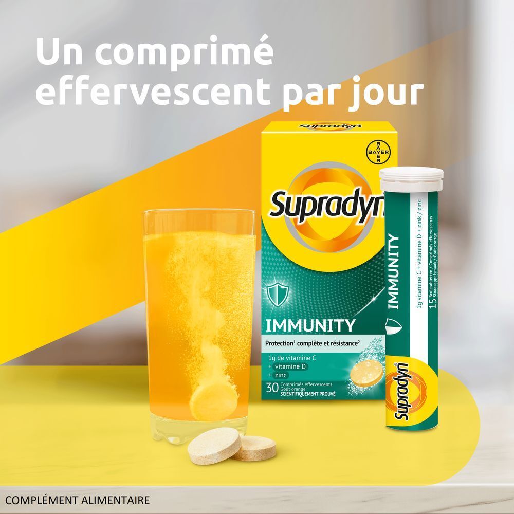 Verre avec comprimé effervescent dissous et emballage Supradyn Immunity. Contient 30 comprimés.