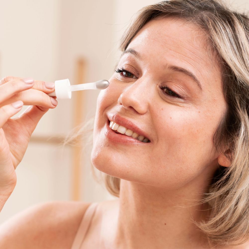 Femme avec pipette près de l'œil. SVR AMPOULE REFRESH.