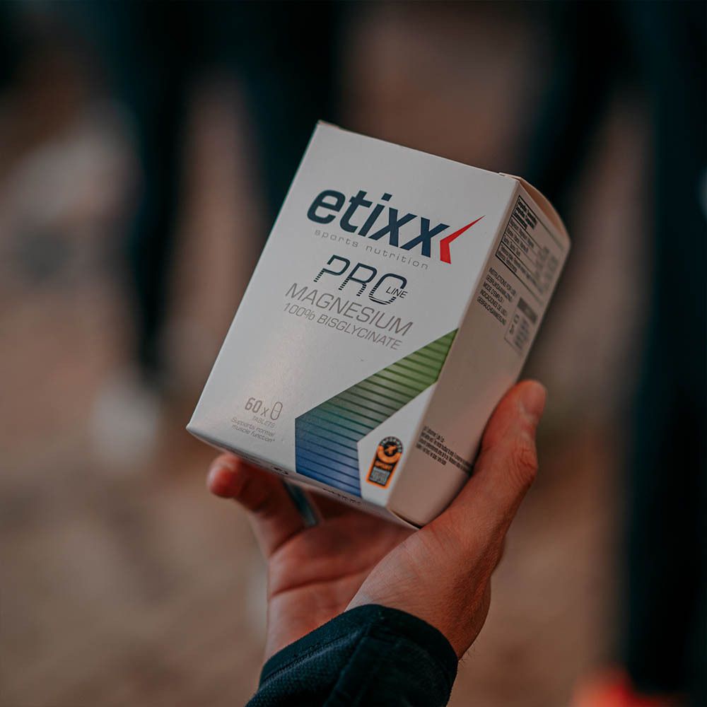 Hand houdt witte doos 'etixx PRO LINE Magnesium' vast. Achtergrond onscherp.