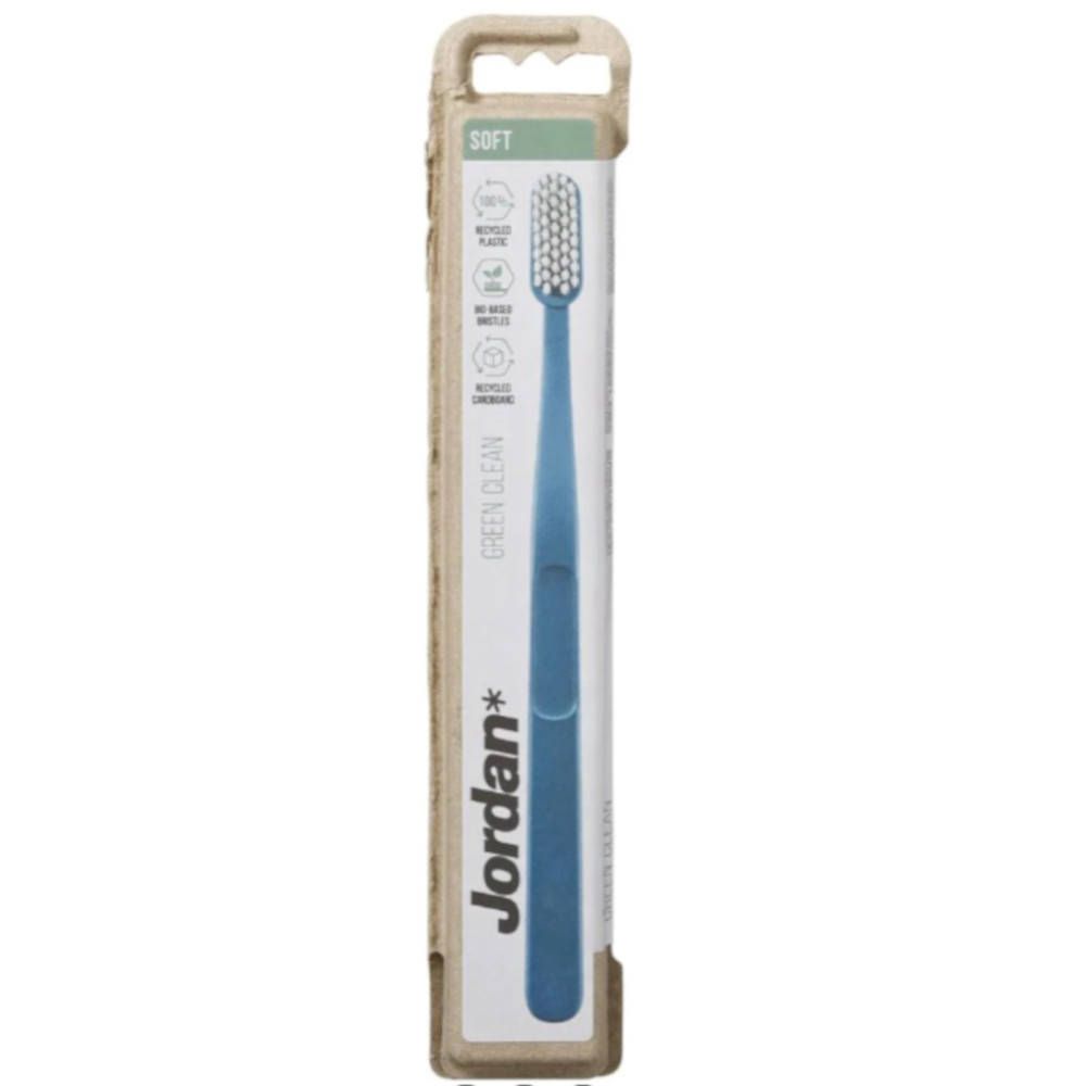 Brosse à dents Jordan Green Clean Soft dans son emballage. Brosse bleue, manche vert. Emballage en matériau recyclé. Texte : Green Clean, Soft.