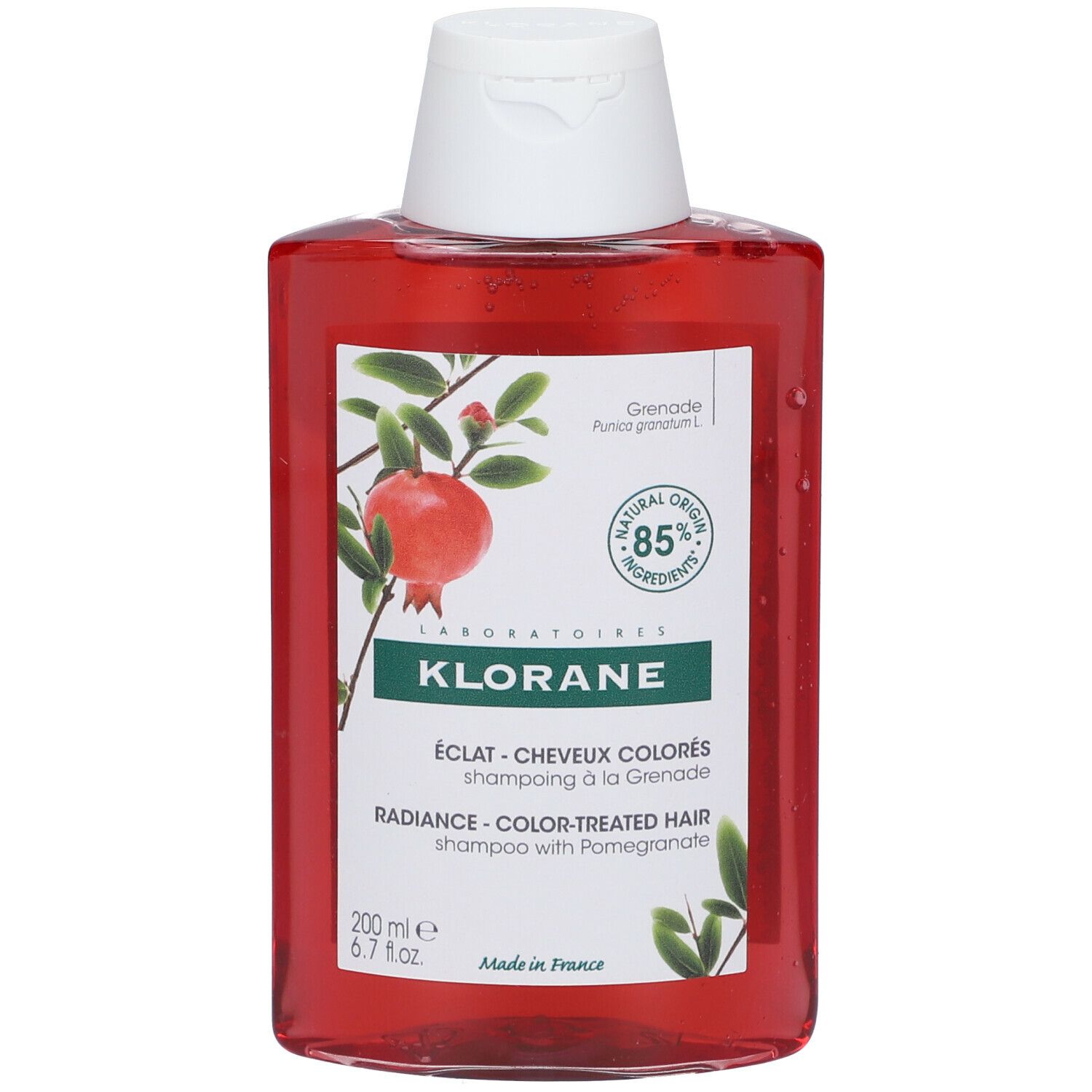 Rode shampoo fles met witte dop. Opschrift: KLORANE, Granaatappel. Etiket met afbeelding van een granaatappelplant.