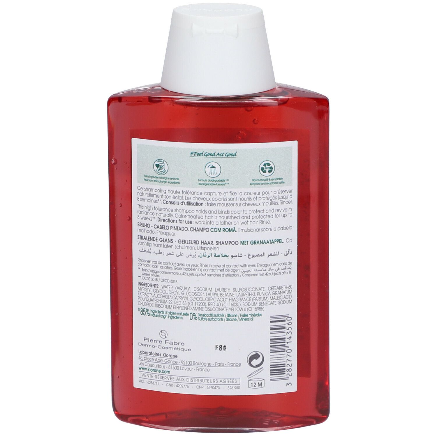 Achterkant van de rode shampoo fles. Tekst en logo's op wit etiket. Ingrediënten en instructies.