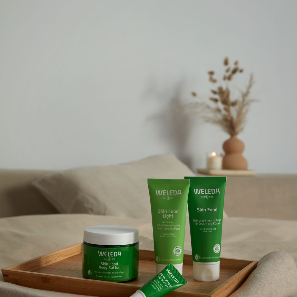 Houten dienblad met Skin Food producten: pot, tubes. Achtergrond: bed en decoratie.