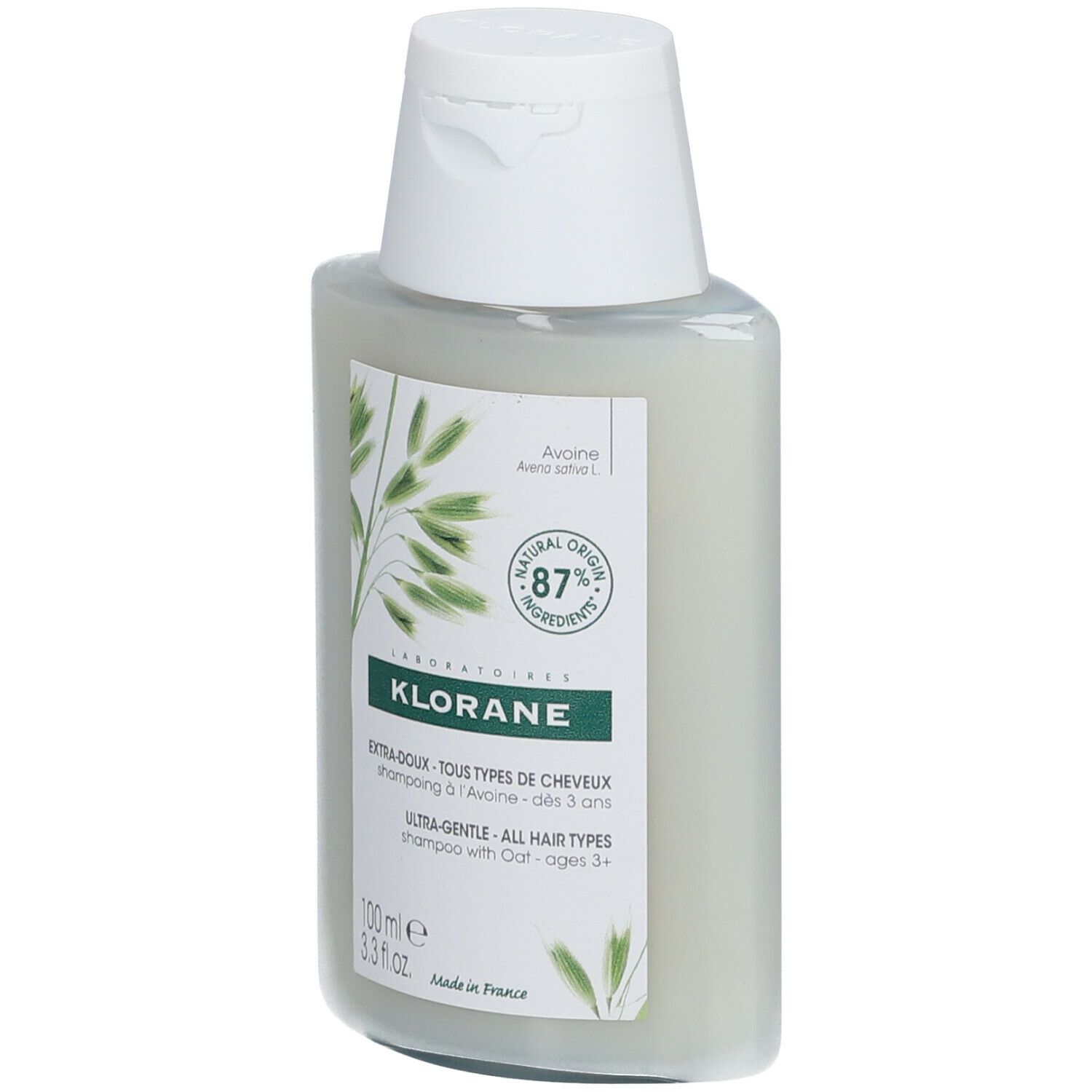 Flacon de shampooing Klorane à l'avoine. Bouchon blanc, étiquettes vertes et blanches. Contient 87% d'ingrédients d'origine naturelle.