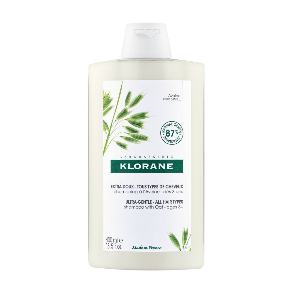 Flacon de shampooing Klorane à l'avoine. Flacon blanc avec étiquette verte. Texte: Extra-Doux, Tous Types de Cheveux, Ultra-Gentle.