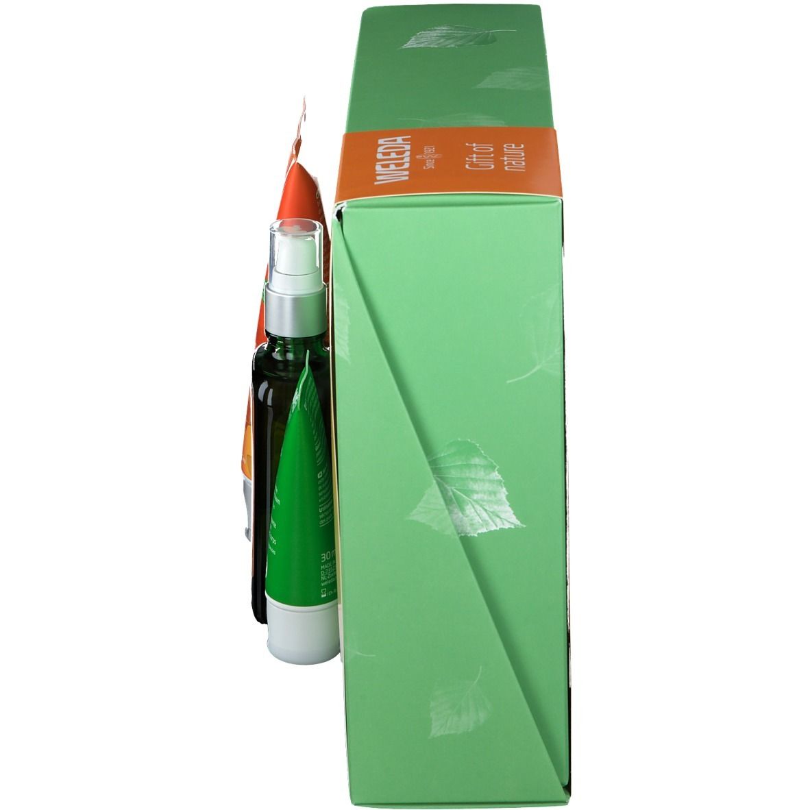 Zijaanzicht van de geschenkverpakking. Groene doos met bladerpatroon. Oranje tube zichtbaar.
