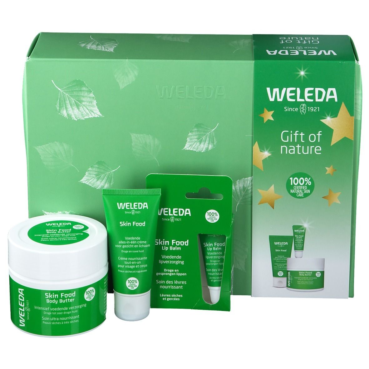 Cadeauset met bodylotion, crème en lippenbalsem. Groene verpakking met bladeren en sterren. Weleda-logo.