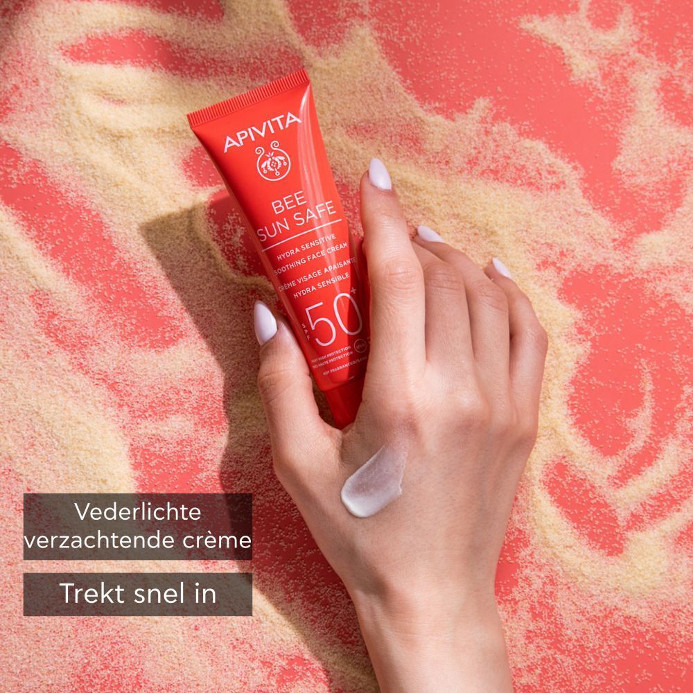 Hand met crème op de huid. Tube APIVITA BEE SUN SAFE. Tekst: 50+.