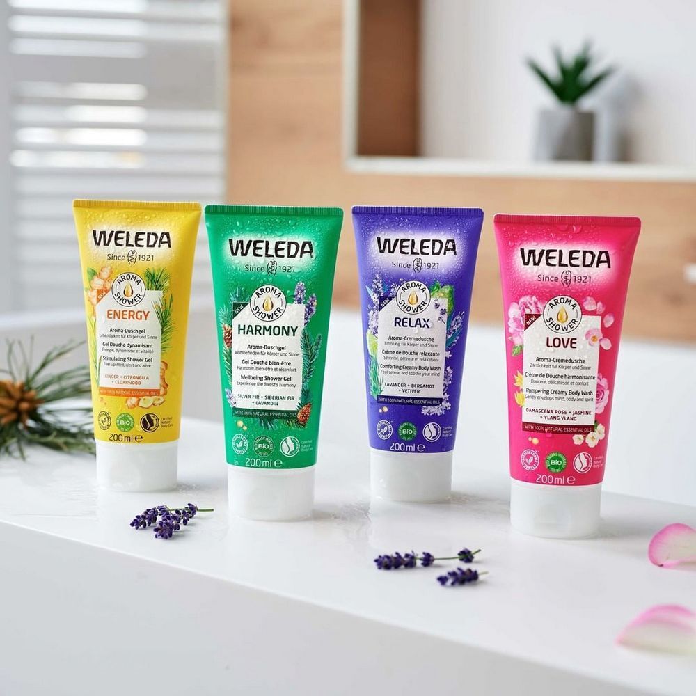 Vier tubes douchegel naast elkaar. Kleuren: geel, groen, paars, roze. Opschrift: WELEDA. Producten: Energy, Harmony, Relax, Love. 200ml.