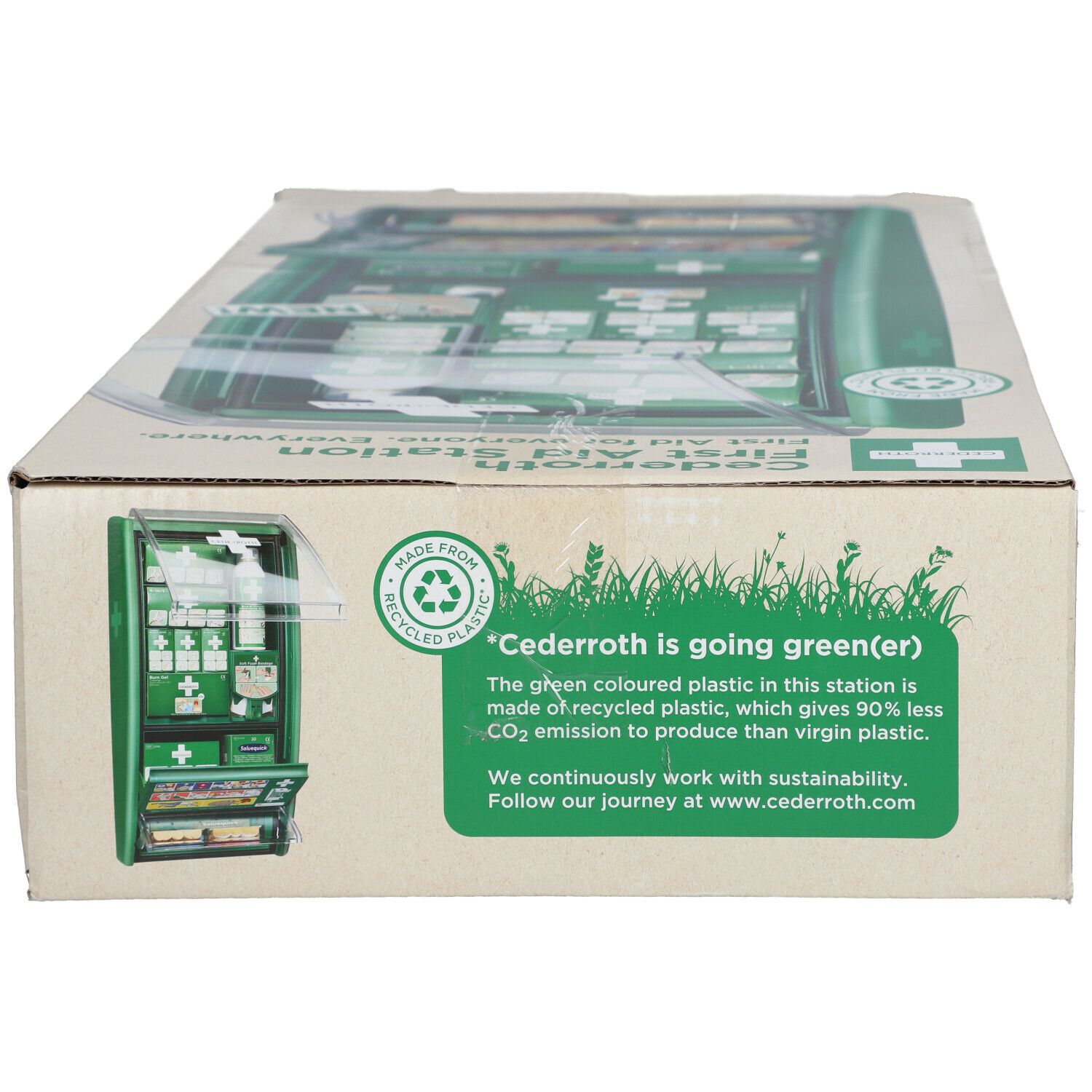 Boîte en carton avec impression. Texte "Cederroth is going green(er)". Image de la station. Boîtier vert avec symbole de premiers secours. Symbole de recyclage.
