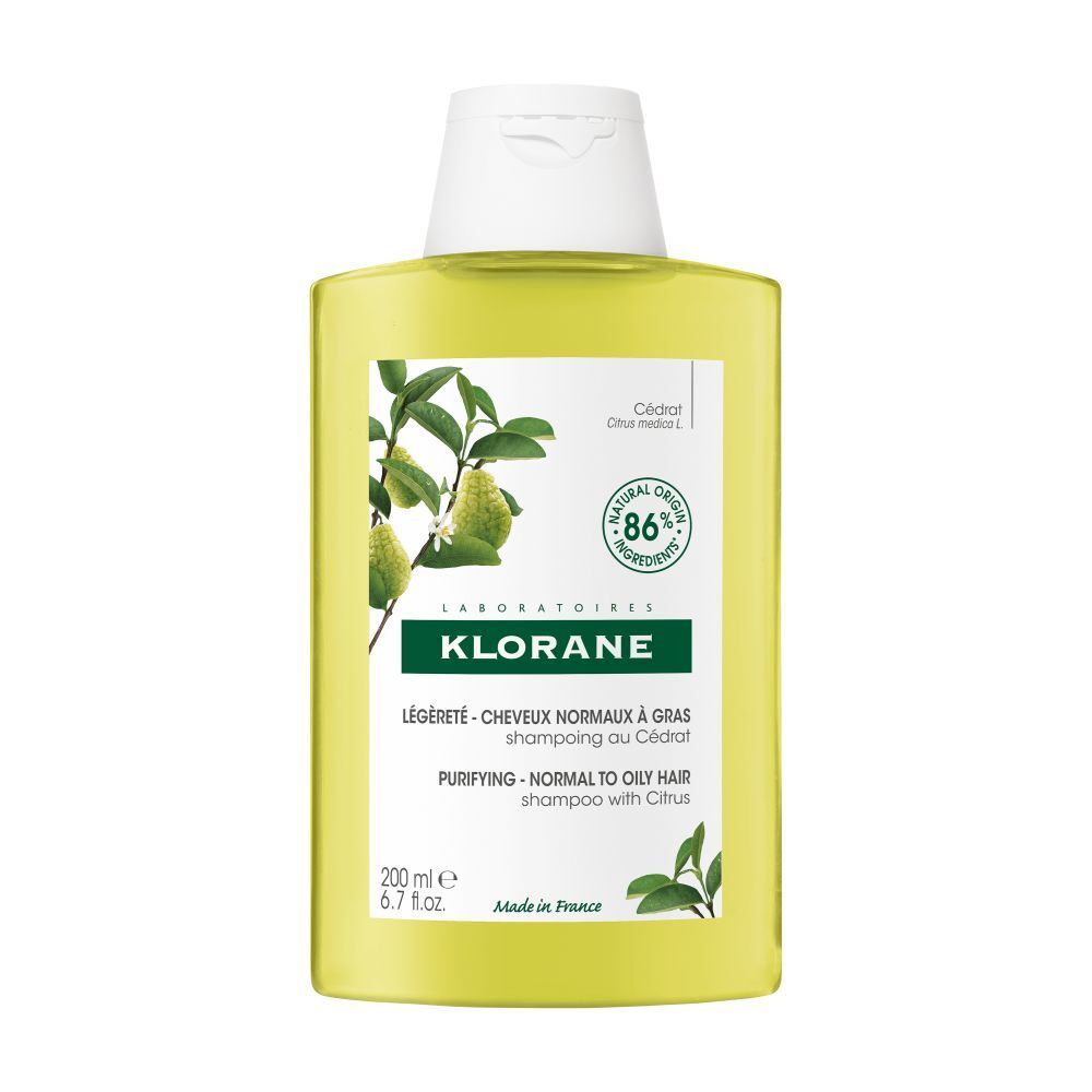 Klorane Shampoo met Cedrat. Gele fles met witte dop. Etiket met productinfo en citrusillustratie.