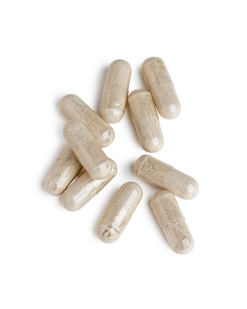 Tien transparante capsules op witte achtergrond. Capsules verspreid.