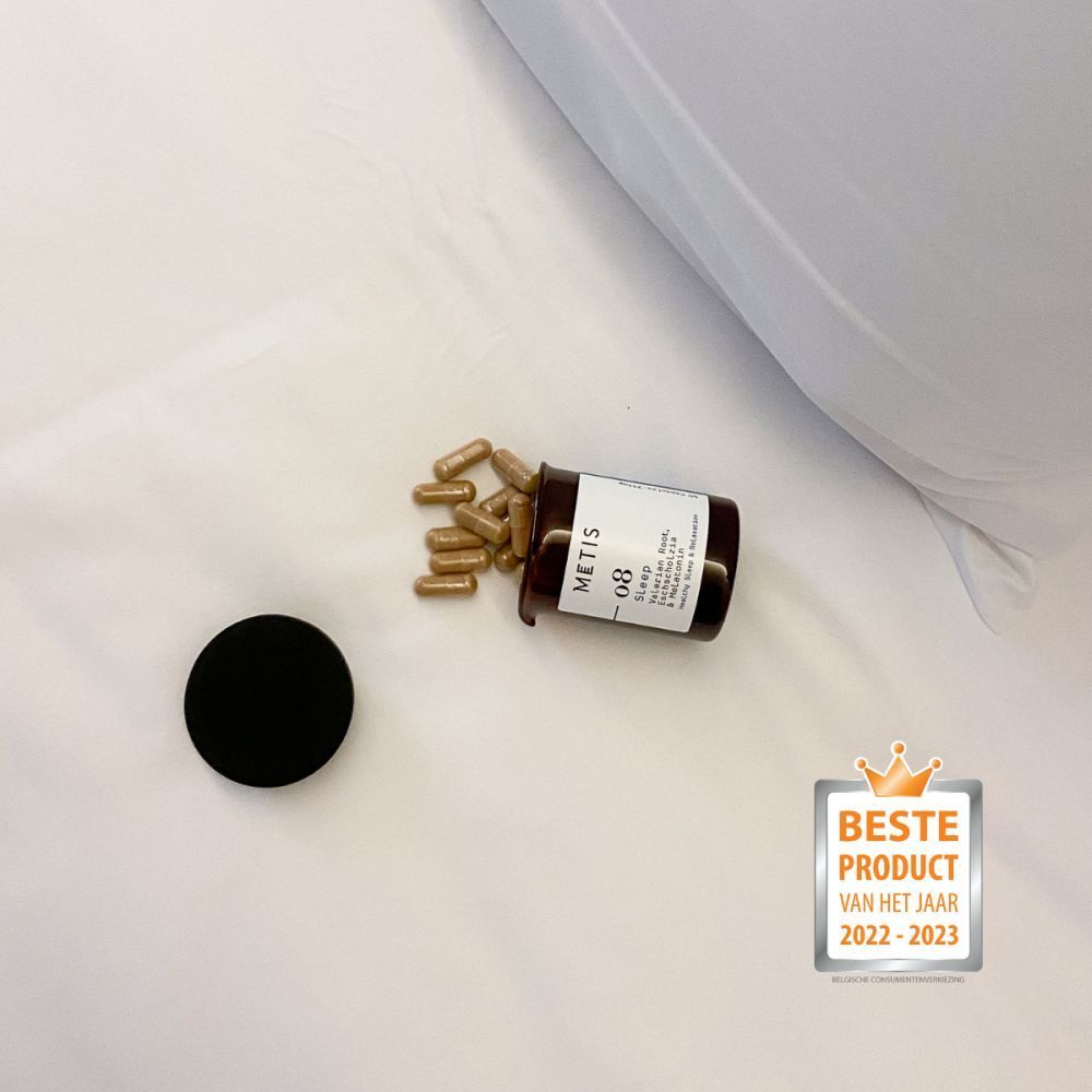 Bruine glazen fles met zwarte deksel ligt omgekiept. Capsules ernaast. Label: METIS 08 Sleep. Onderscheiding.