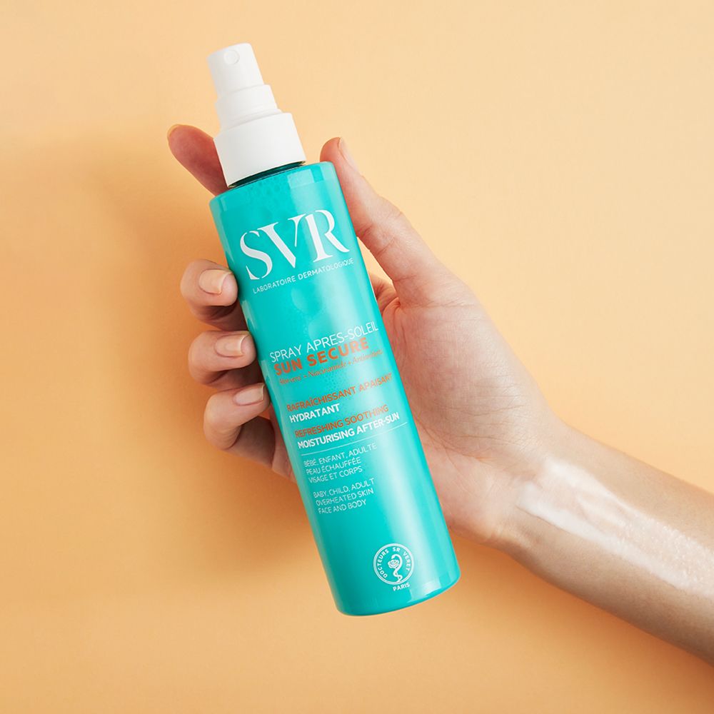 Hand houdt turquoise sprayfles met witte sproeikop vast. Opschrift SVR, Sun Secure, Spray Après-Soleil.