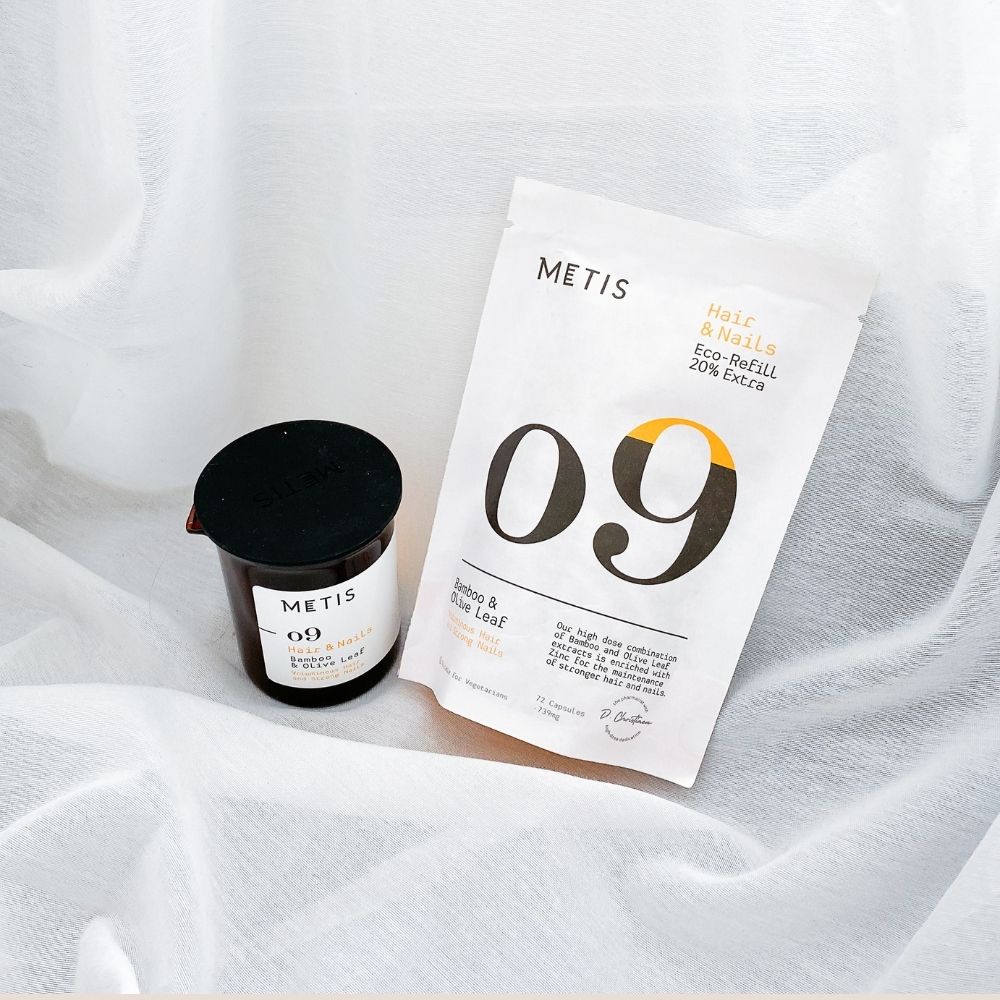 Potje en zak met "09". "METIS" logo en productinformatie. Gedrapeerd op witte stof.
