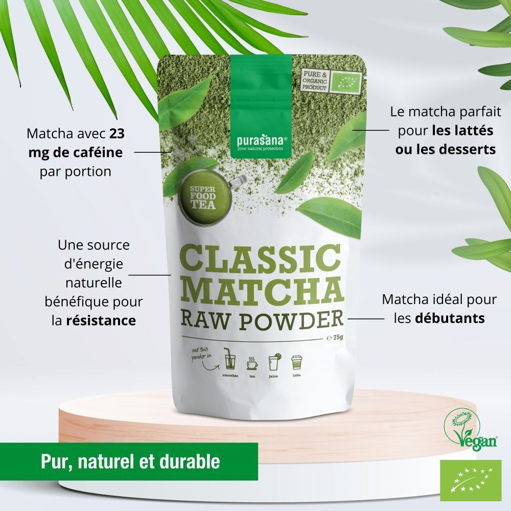 Emballage Classic Matcha Raw Powder. Texte: Matcha avec 23 mg de caféine par portion. Label Vegan. Sur socle avec feuilles.