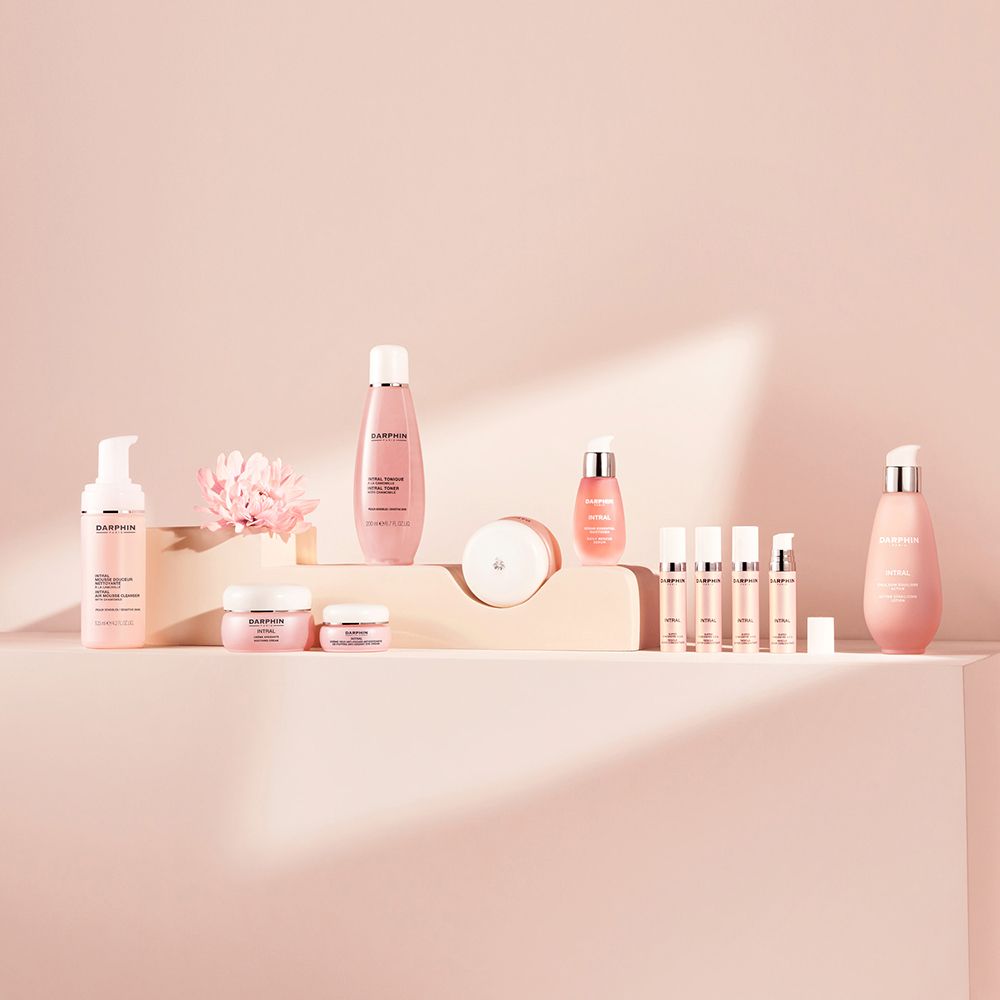 Verschiedene Produkte auf rosa Podest. Flaschen, Tiegel, Tuben. Text: Darphin.