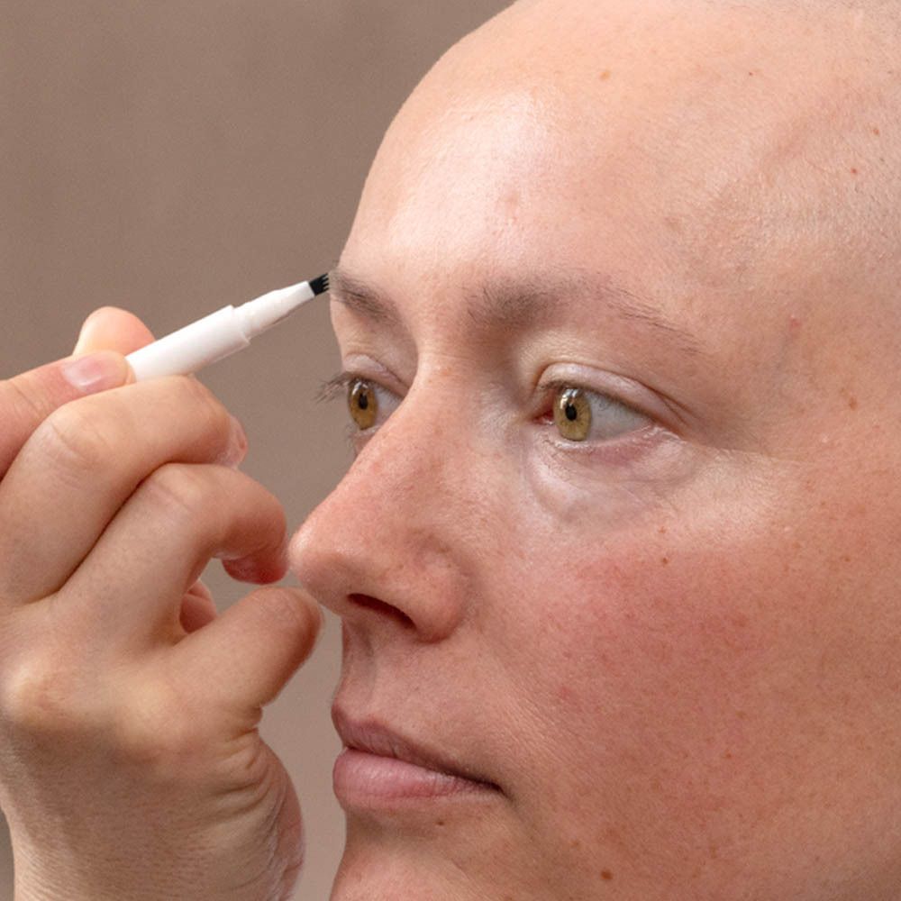 Persoon tekent wenkbrauw met MÊME wenkbrauwpotlood. Eye and brow liner. Toepassing.