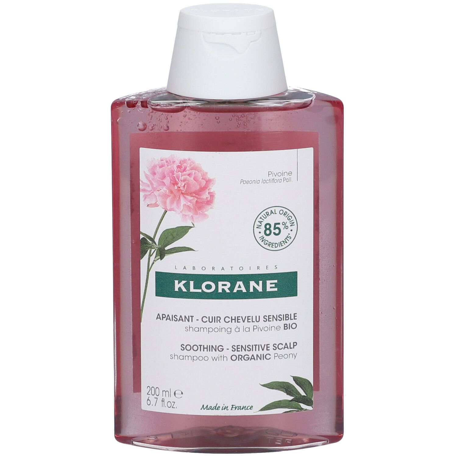 Klorane shampoo met pioenroos. Roze vloeistof in rechthoekige fles met witte dop. Etiket met bloem.