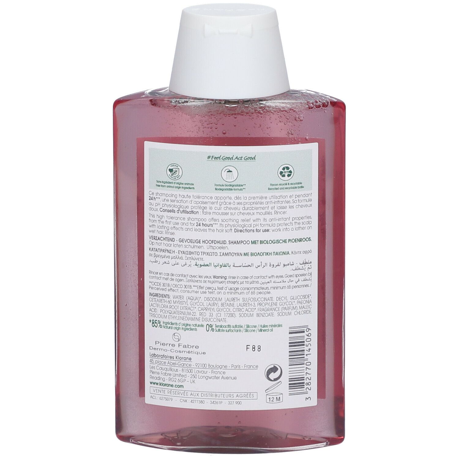 Achterkant van de Klorane shampoo fles. Roze vloeistof in rechthoekige fles met witte dop. Tekst en etiketten.