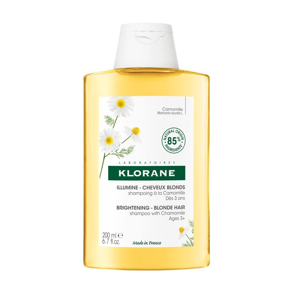Shampoo KLORANE à la camomille. Flacon jaune avec bouchon blanc et étiquette avec fleurs de camomille.