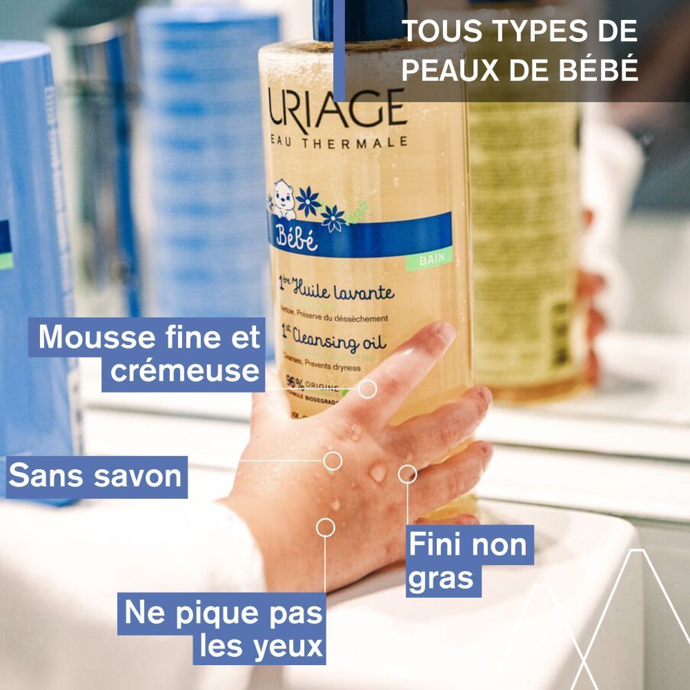 Image produit avec texte. Uriage Bébé 1ère Huile lavante. Main de bébé avec gouttes. Arrière-plan avec produits.