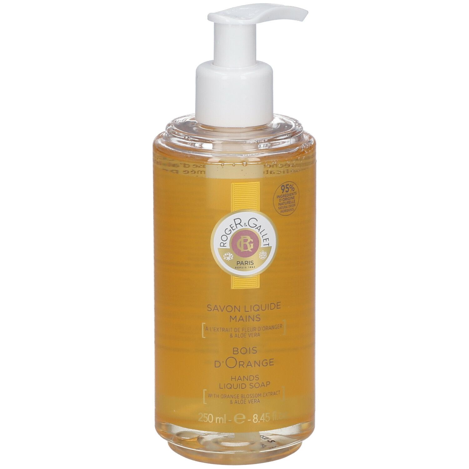 Savon liquide avec pompe. Récipient transparent avec liquide jaune. Inscription: Savon Liquide Mains, Bois d'Orange, 95% d'ingrédients d'origine naturelle.