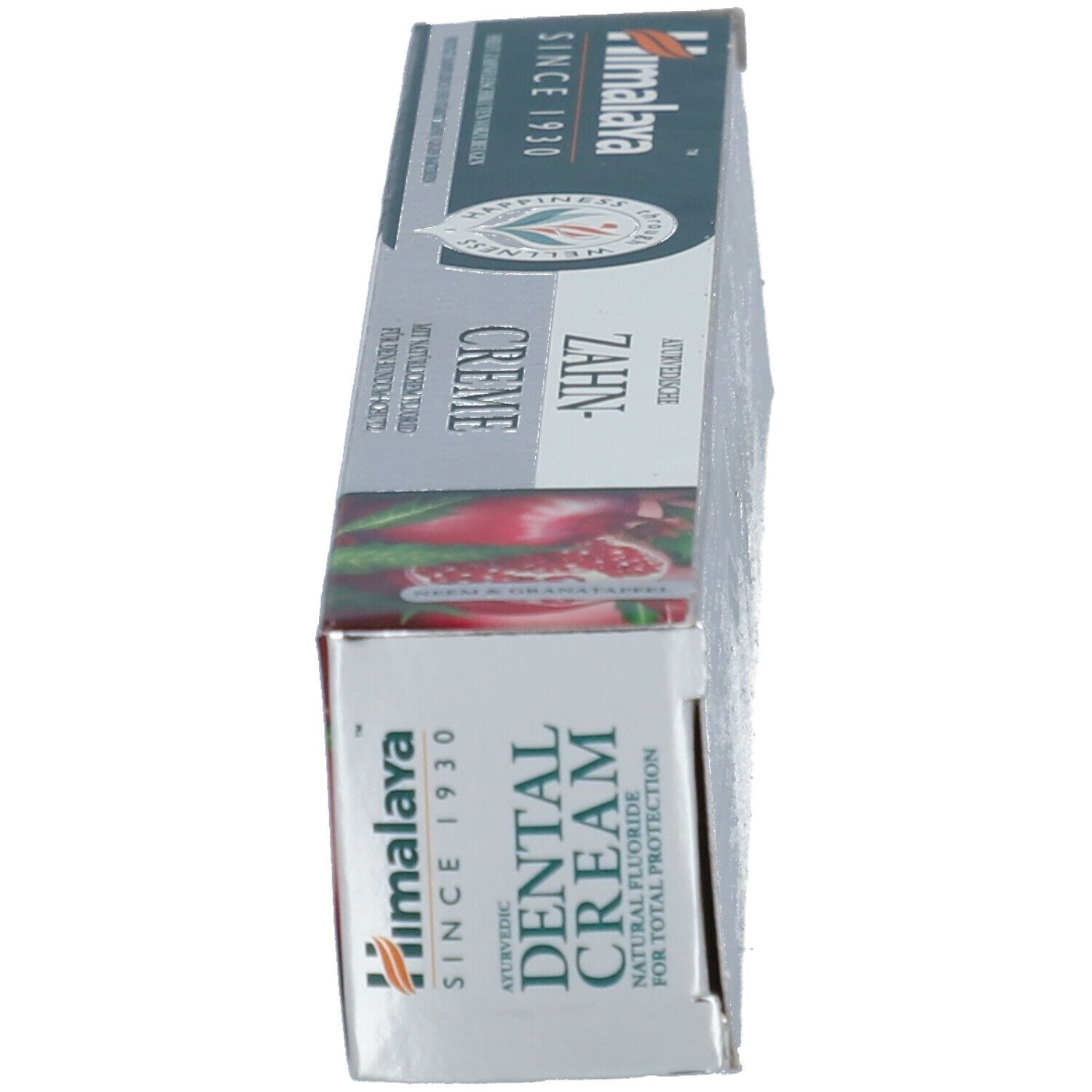Schachtel, weiß, grün, rot. Text: Dental Cream, Himalaya. Abbildung von Granatapfel. Aufschrift: Zahncreme.