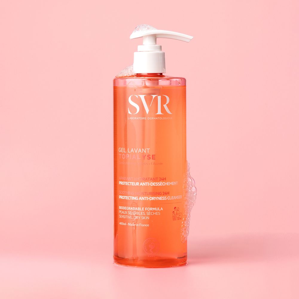 Flacon SVR Gel Lavant Topialyse avec mousse. Liquide rose. Pompe doseuse blanche.