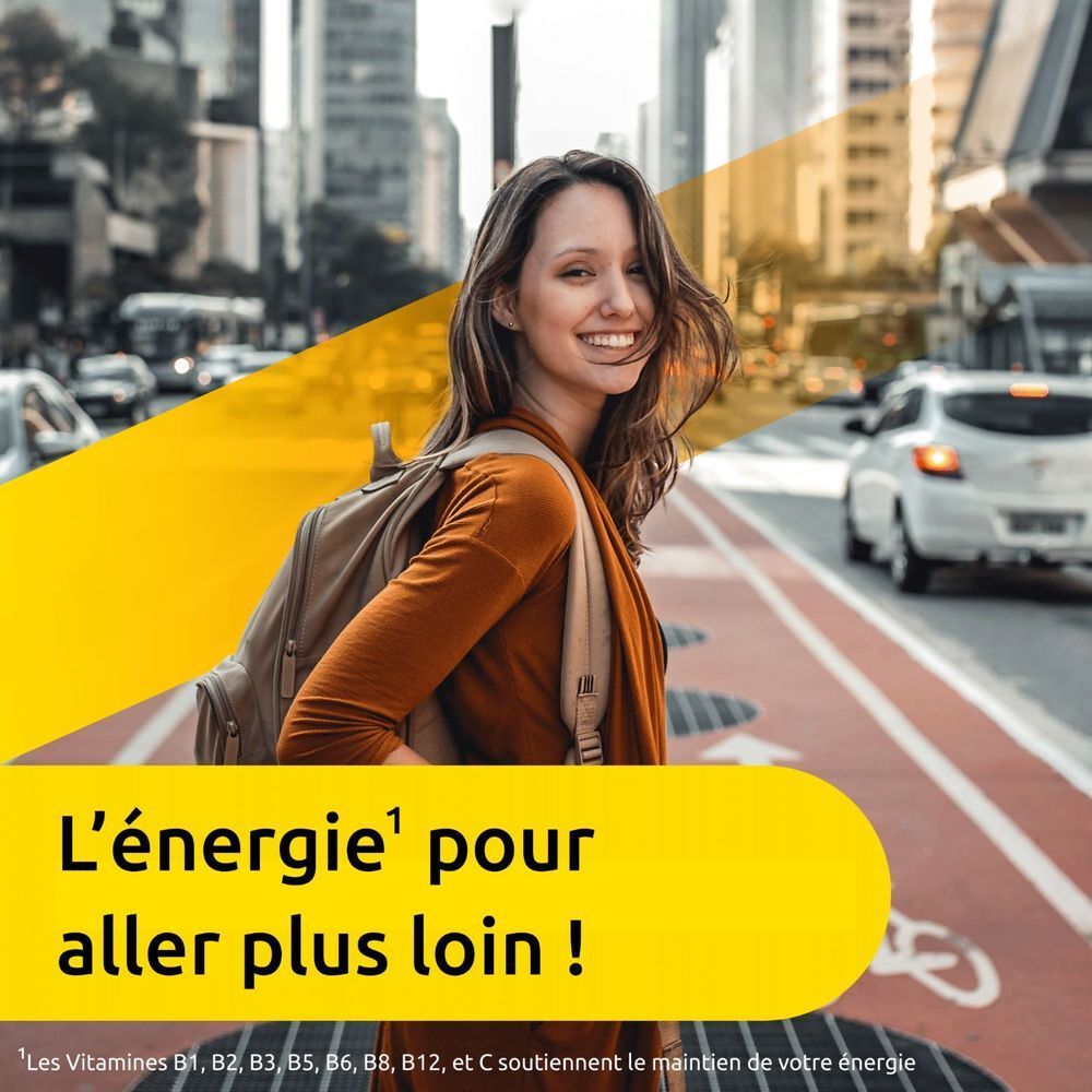 Une femme traverse la rue. Fond : logo jaune et texte : L'énergie pour aller plus loin !