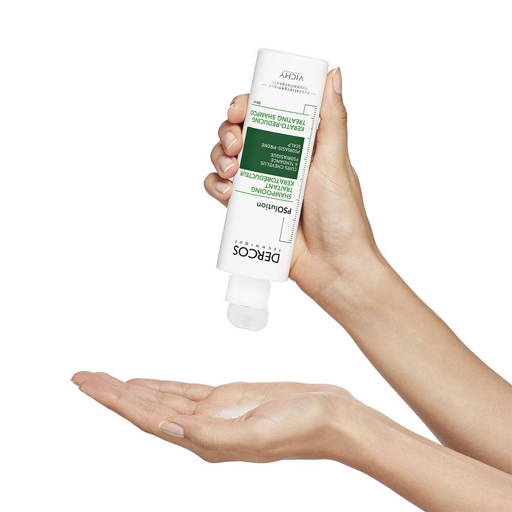 Handen houden een fles vast. Product wordt in de palm gedrukt. Tekst: Dercos, PSolution, Shampooing Traitant Kératoréducteur.