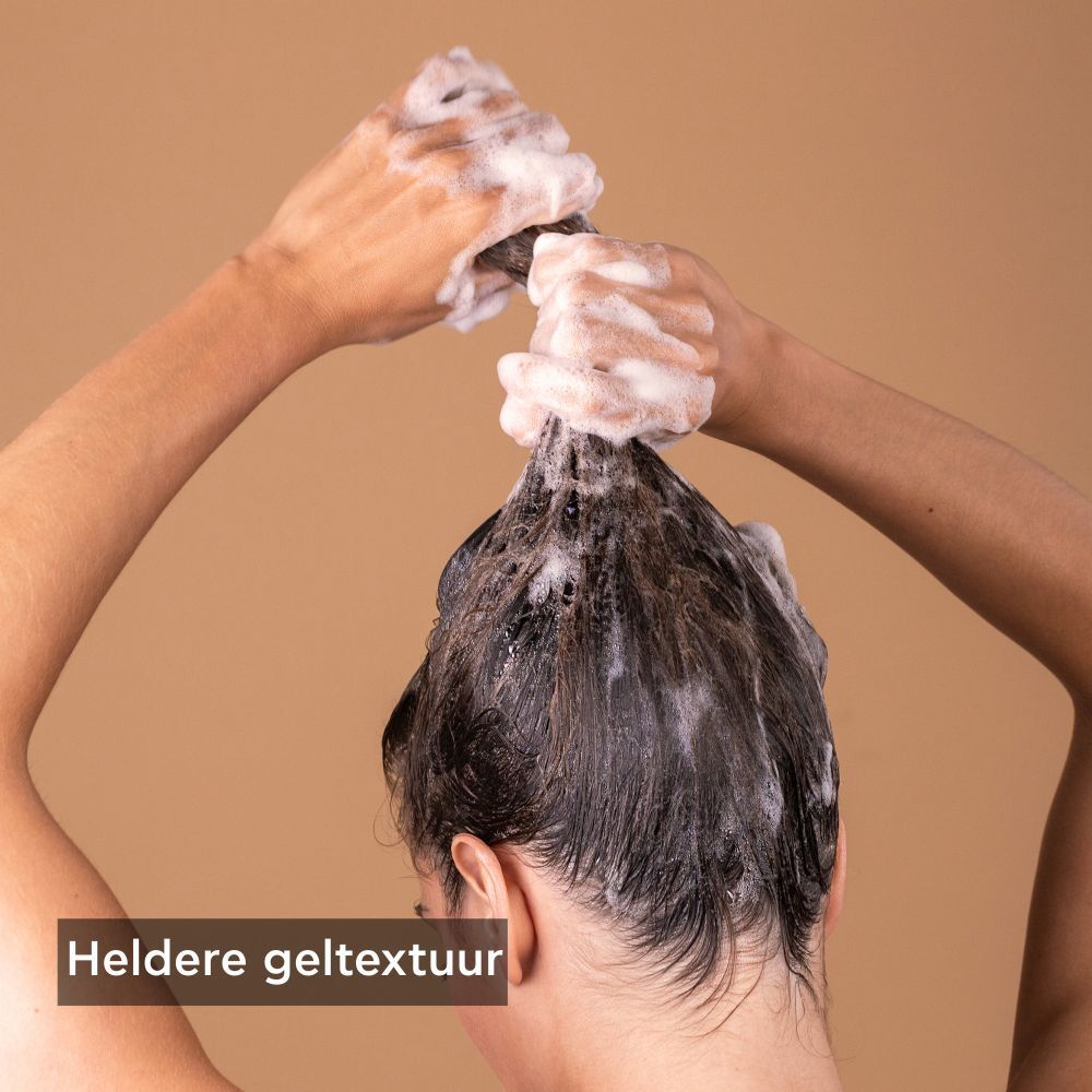 Handen wassen haar met schuim. Tekst: Heldere geltextuur.