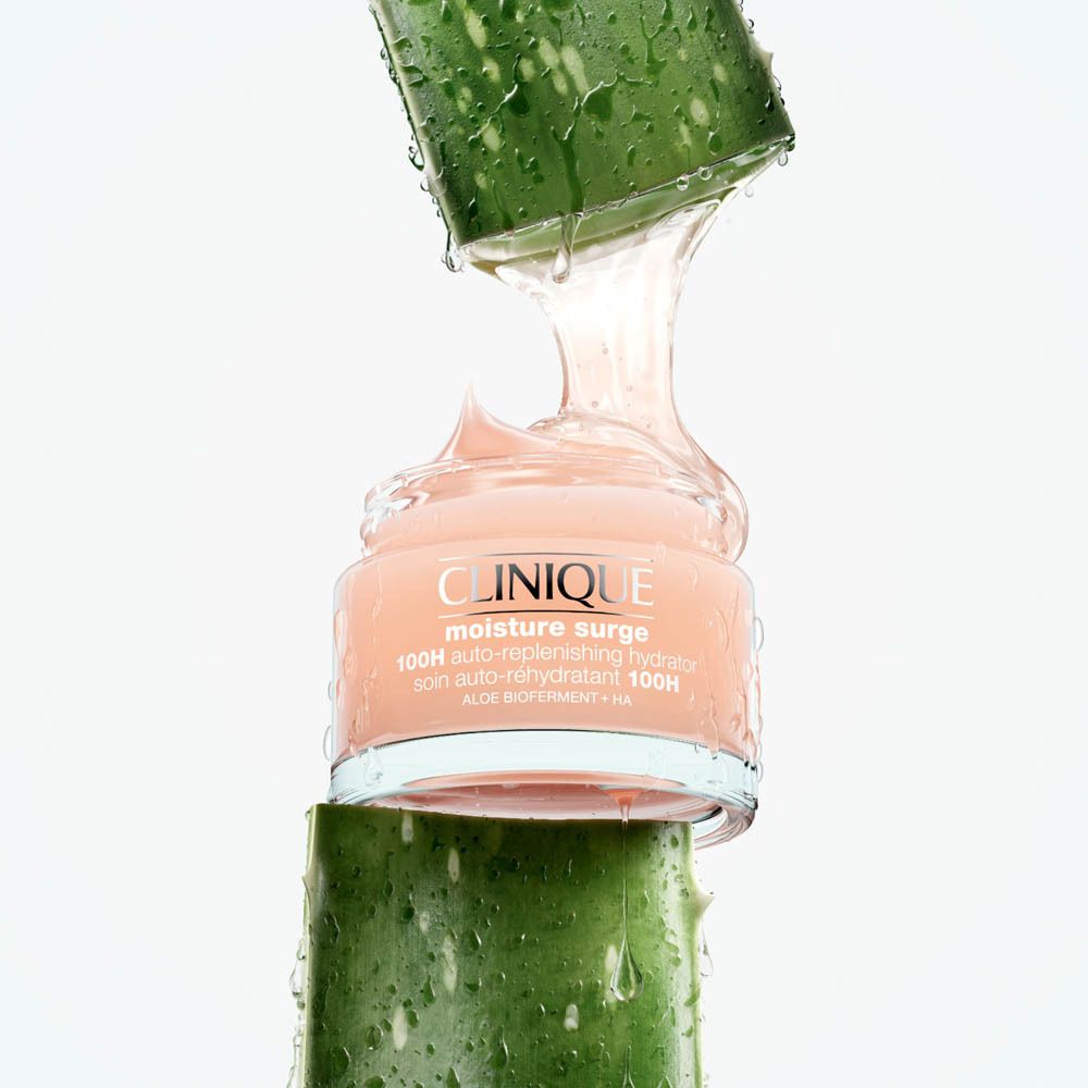 Clinique Moisture Surge Feuchtigkeitscreme in einem Glasbehälter, umgeben von Aloe Vera.