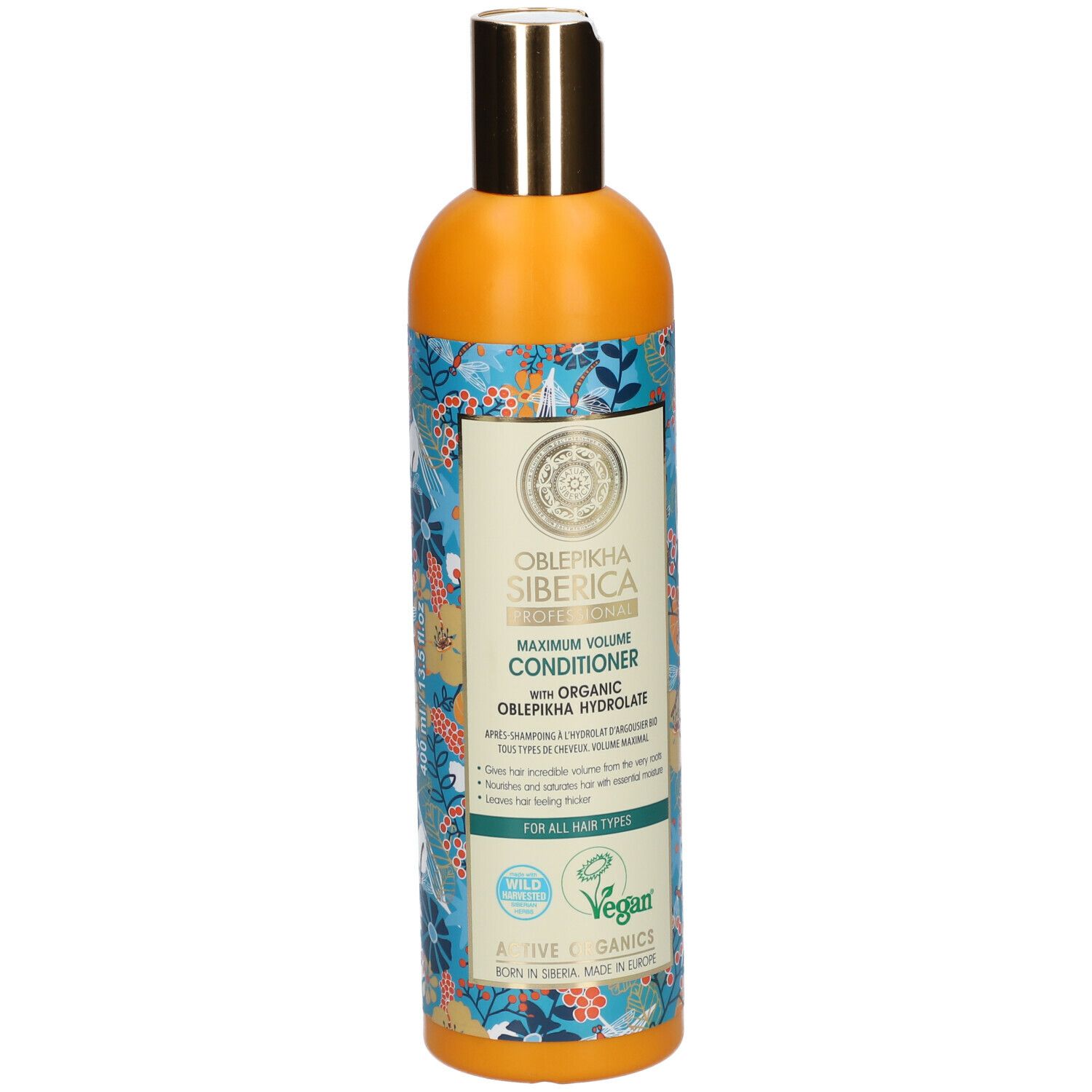 Oranje fles met gouden dop. Etiket met productnaam en bloemenpatroon. Veganistisch zegel.
