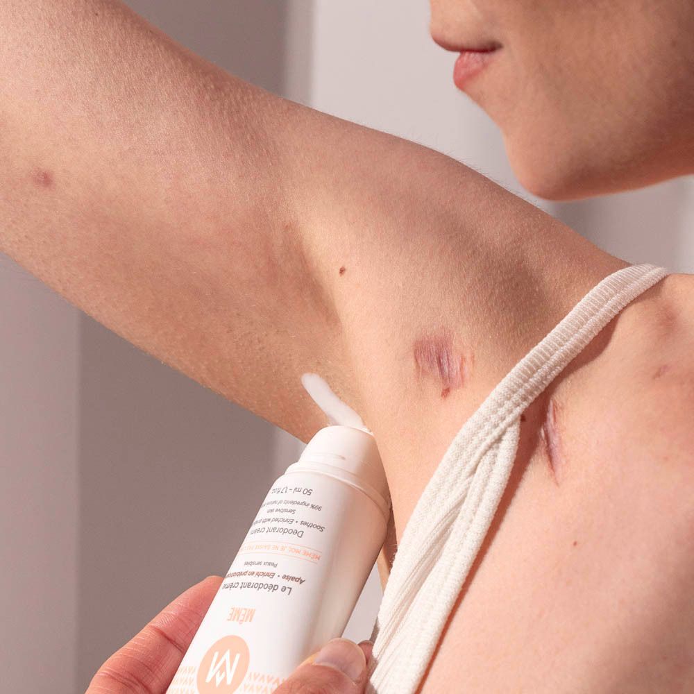 Persoon brengt crème deodorant aan. Toepassing onder de arm. Huid zichtbaar.