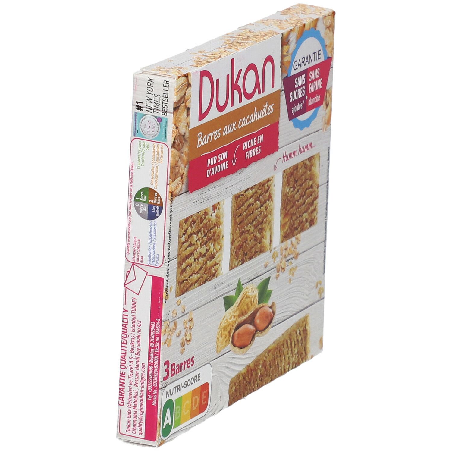 Zijaanzicht van de Dukan pinda reep verpakking. 3 repen, pinda's, havervlokken. Opschrift: Zonder toegevoegde suikers, zonder witte bloem. New York Times.